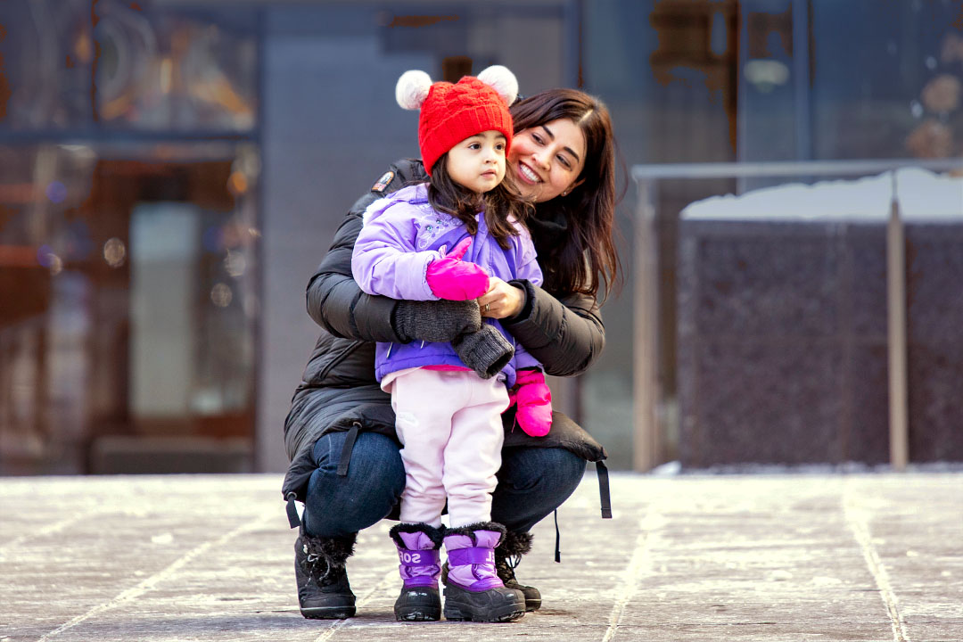 adult female and toddler girl outdoors in winter