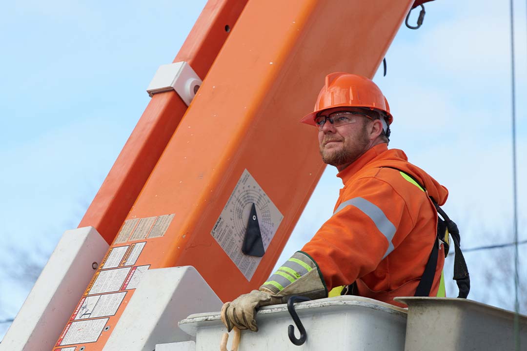 male hydro worker standing in bucket truck